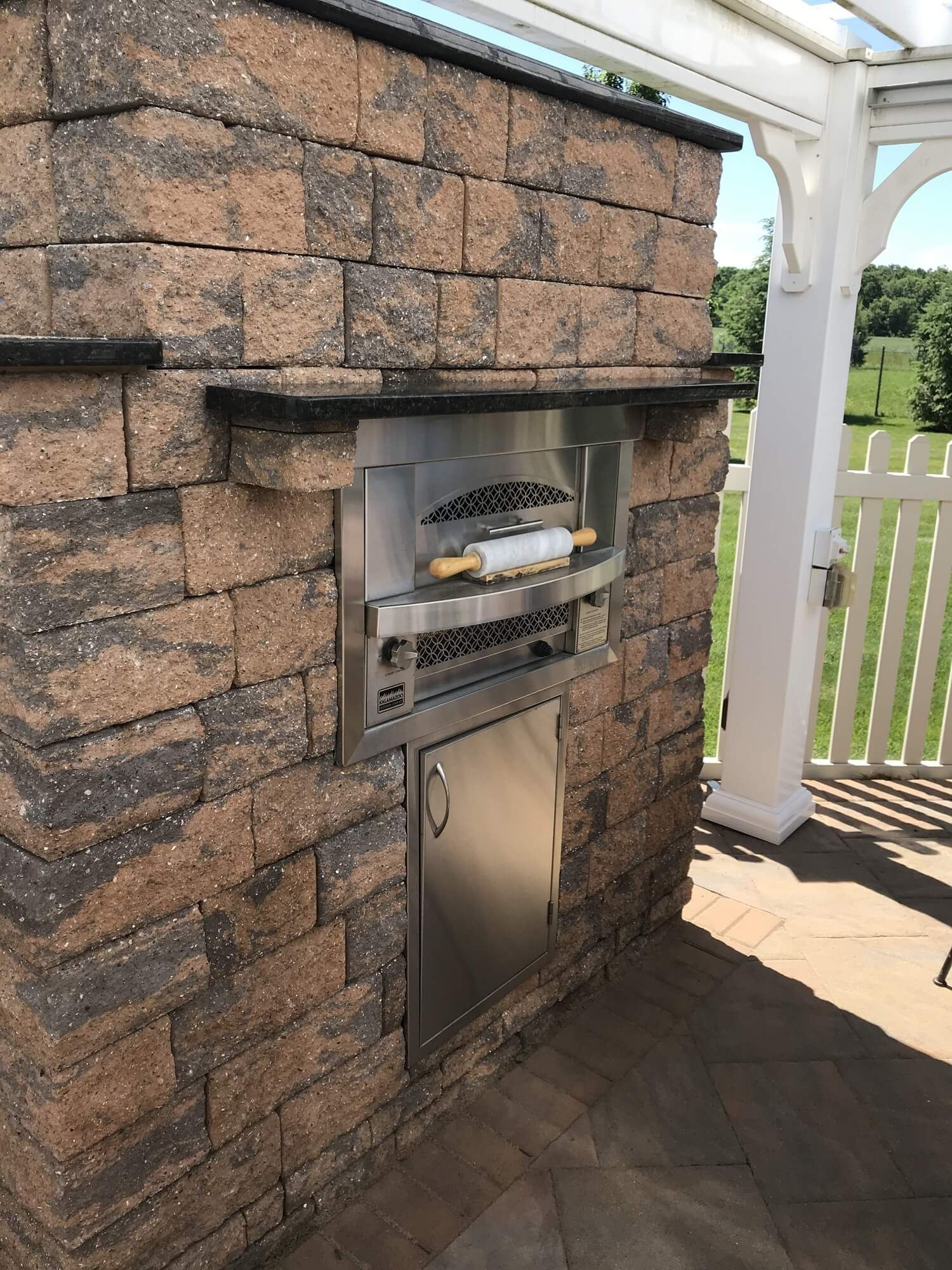 Fireplace underneath pergola | outdoor kitchen trends | Creative Pavers