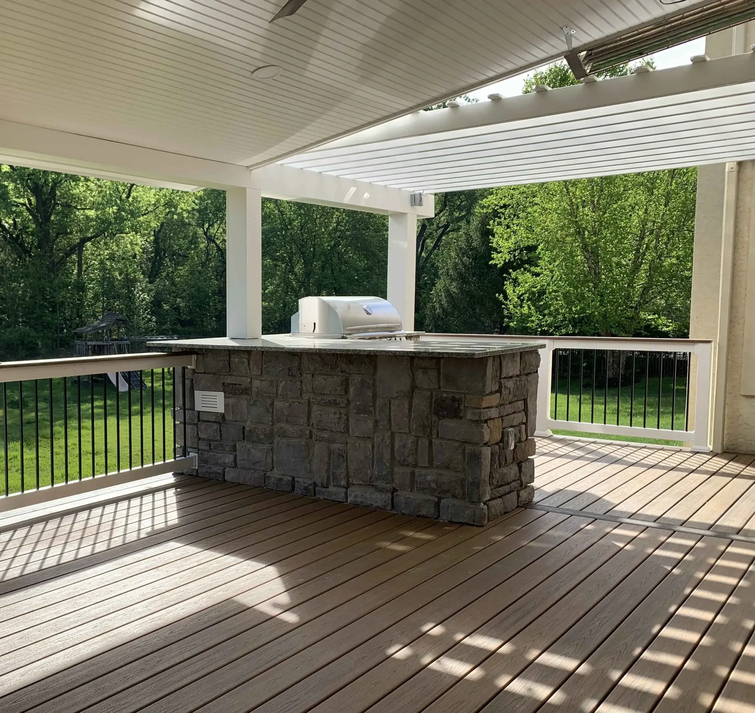 Backyard deck with home kitchen counter and grill | deck additions | Creative Pavers