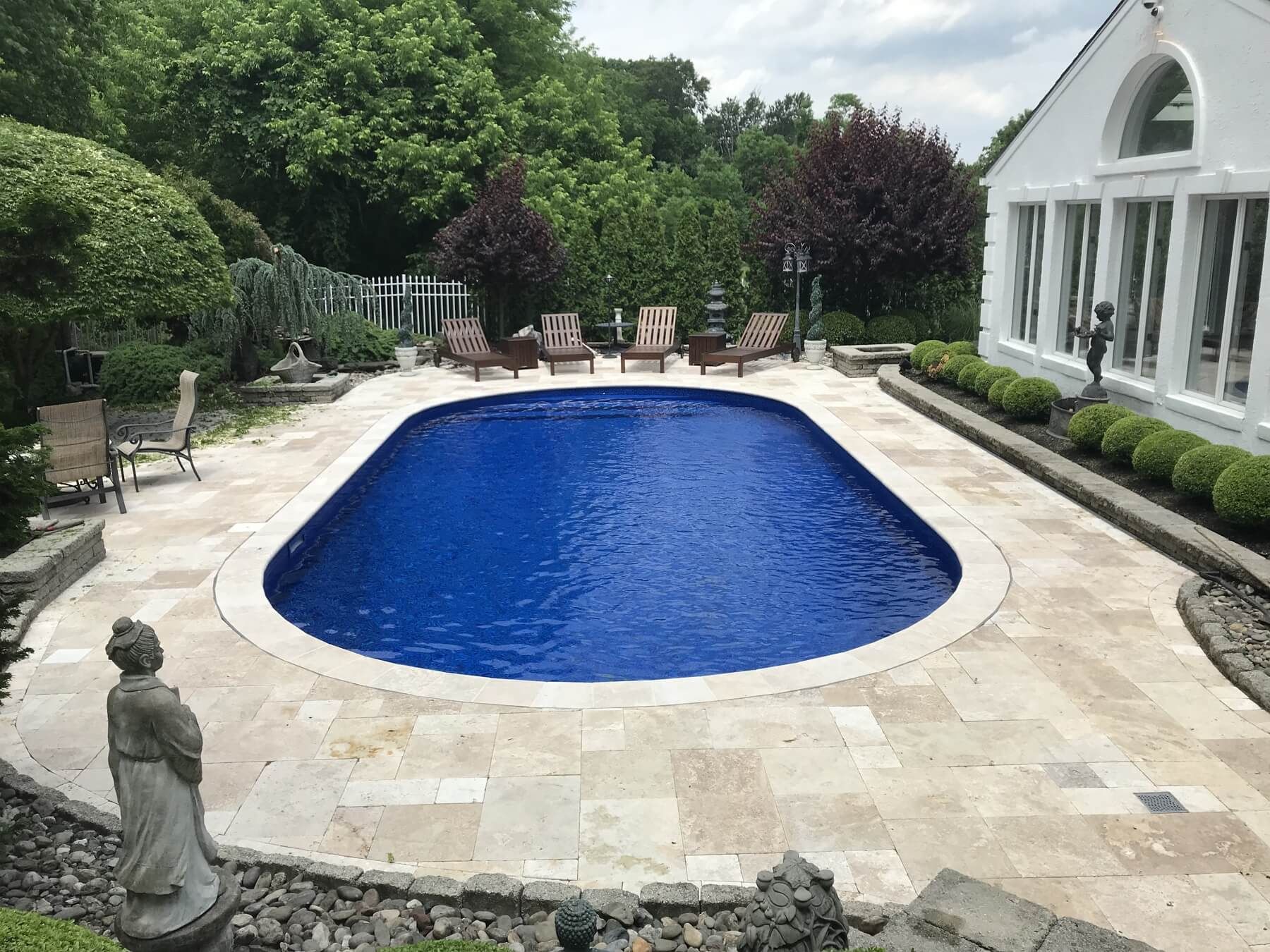 Backyard pool with statues nearby and chairs | Pool Maintenance | Creative Pavers