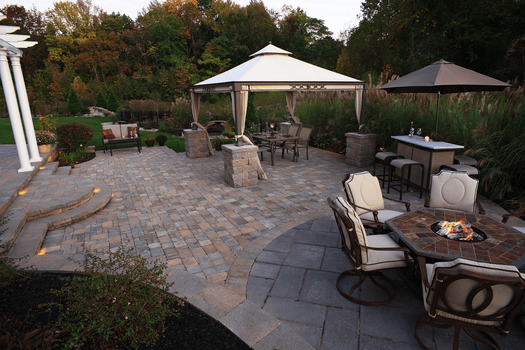 Fireplace underneath pergola | outdoor kitchen trends | Creative Pavers